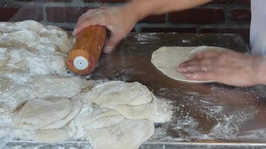 女人揉捏面团面粉粉滚动销墨西哥玉米粉圆饼女准备拉丁美国玉米面包烹饪过程玉米拉美裔面包墨西哥煎玉米卷nacho玉米煎饼包装